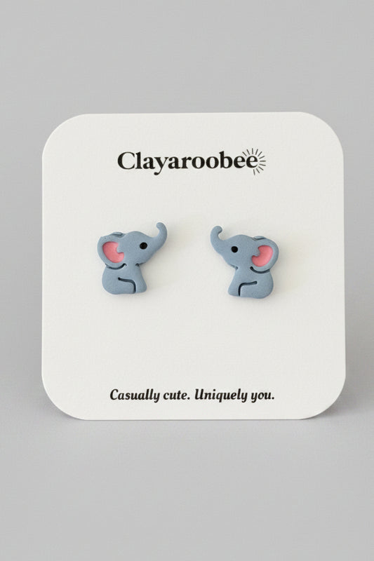 A pair of small elephant stud earrings on a white display card. The card is printed with the brand name 'Clayaroobee' 